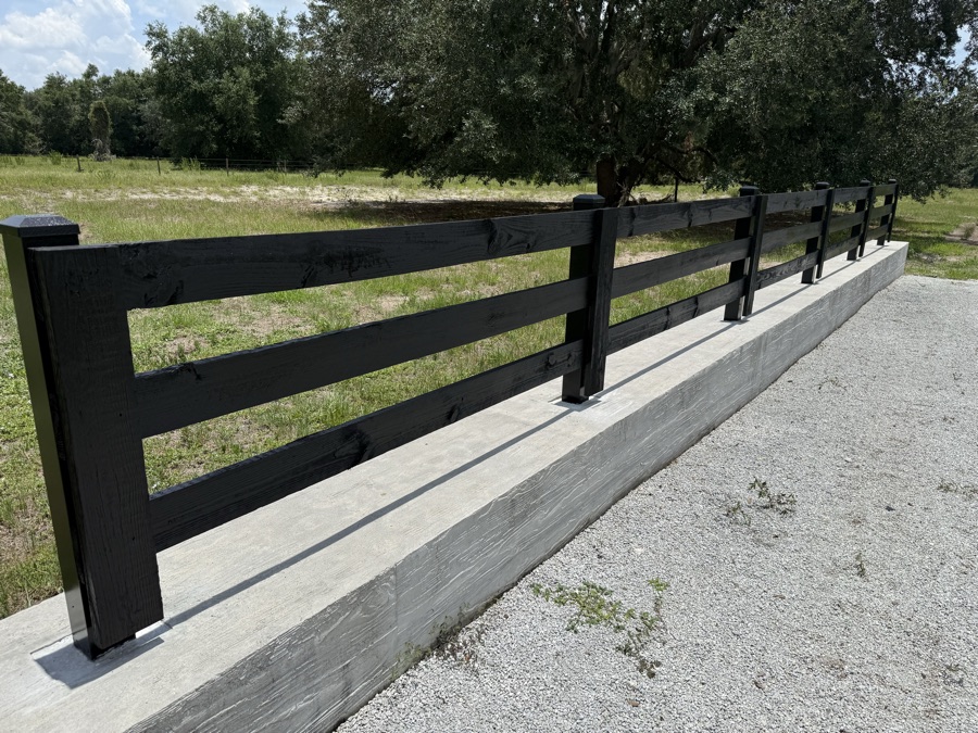 Finished black fence along a driveway entrance