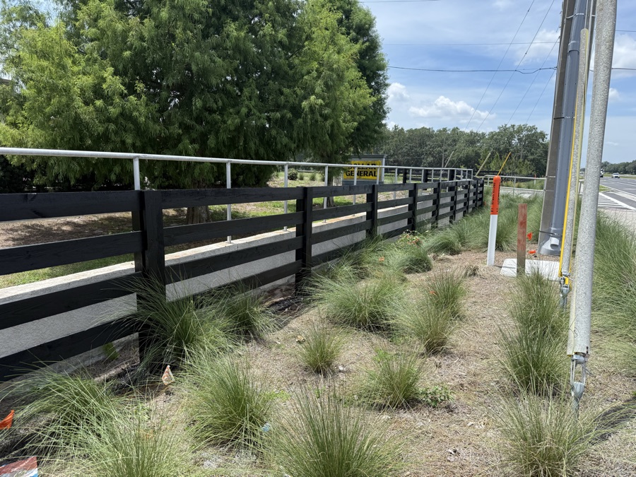 Finished black fence along a roadside property