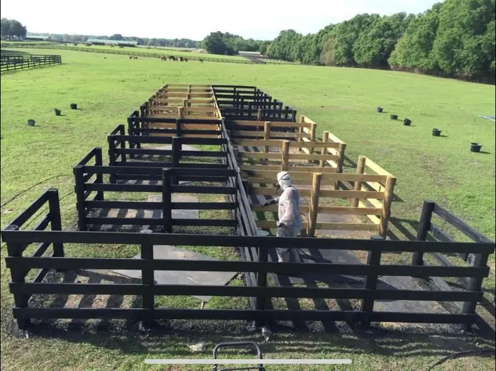Long farm fence painting project in progress