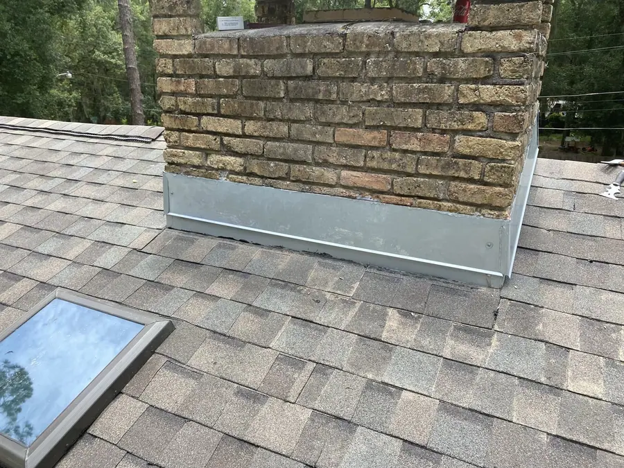 Finished chimney flashing detail on a shingle roof