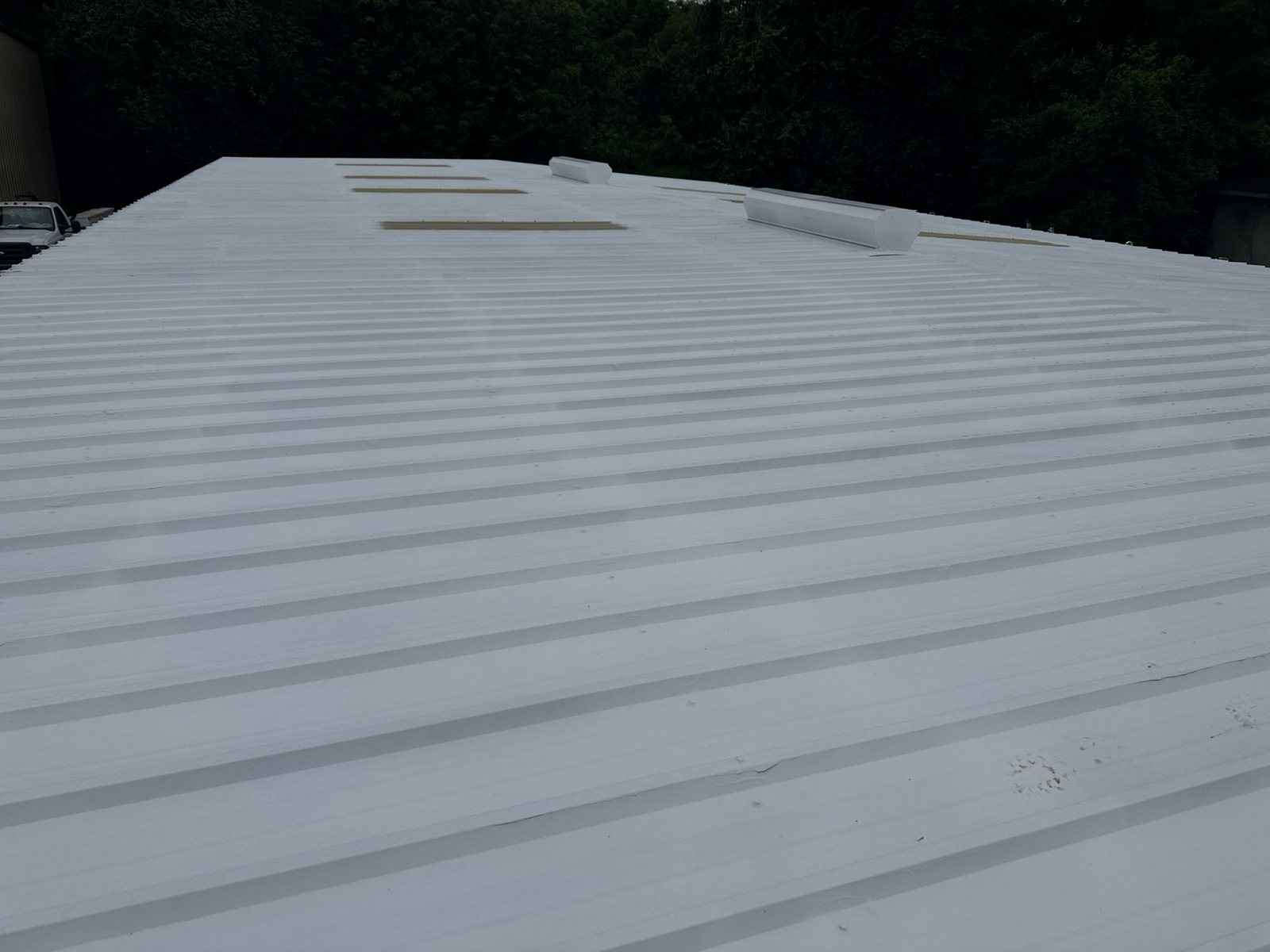 Finished liquid-applied roof coating on a wide roof surface