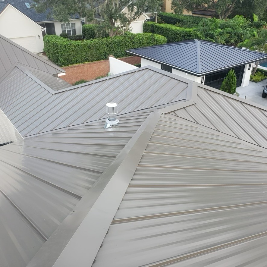 Finished standing seam metal roof with ridge caps and a roof vent in Ocala, Florida