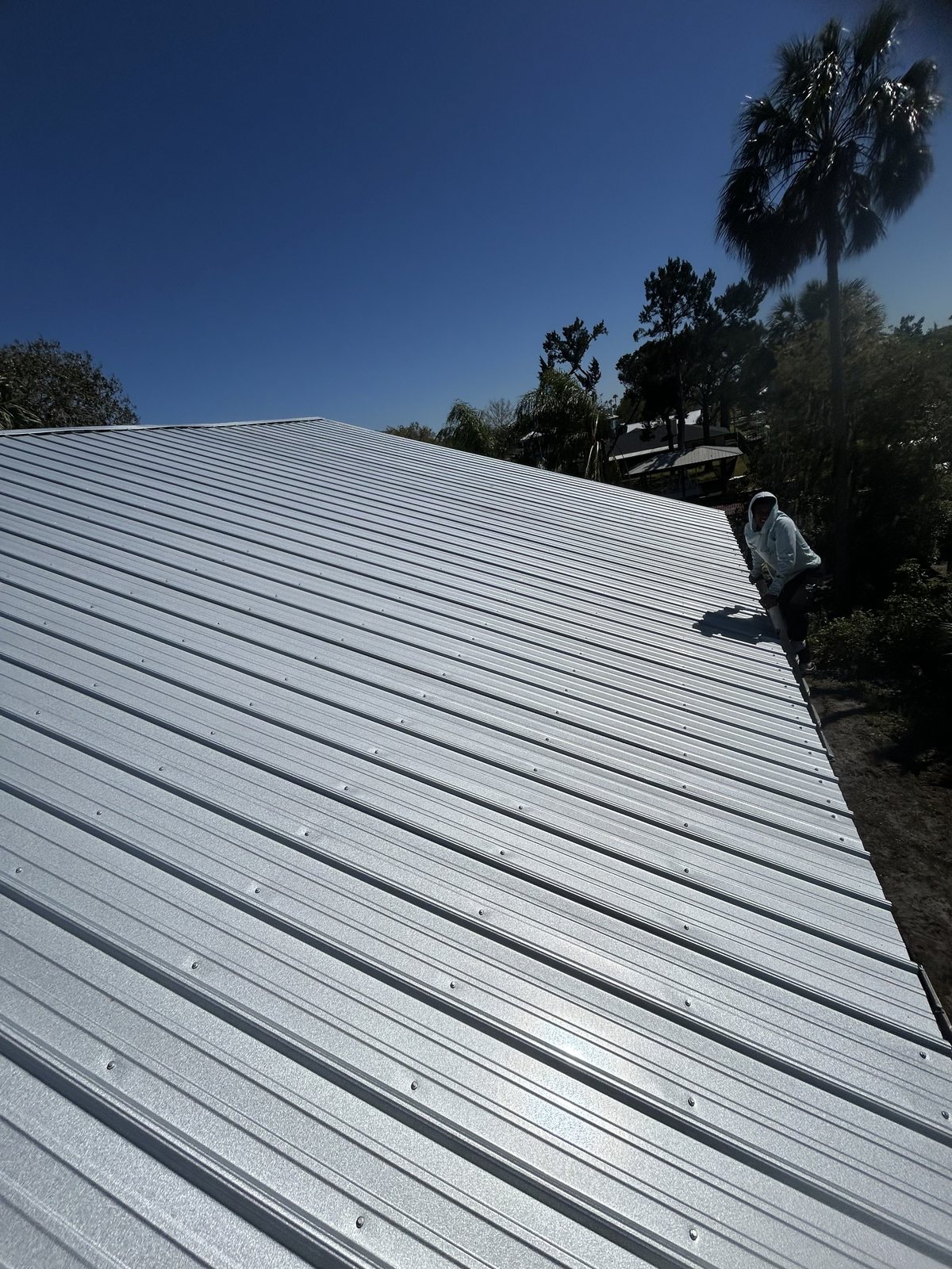 Roofing installer working on a metal roof panel