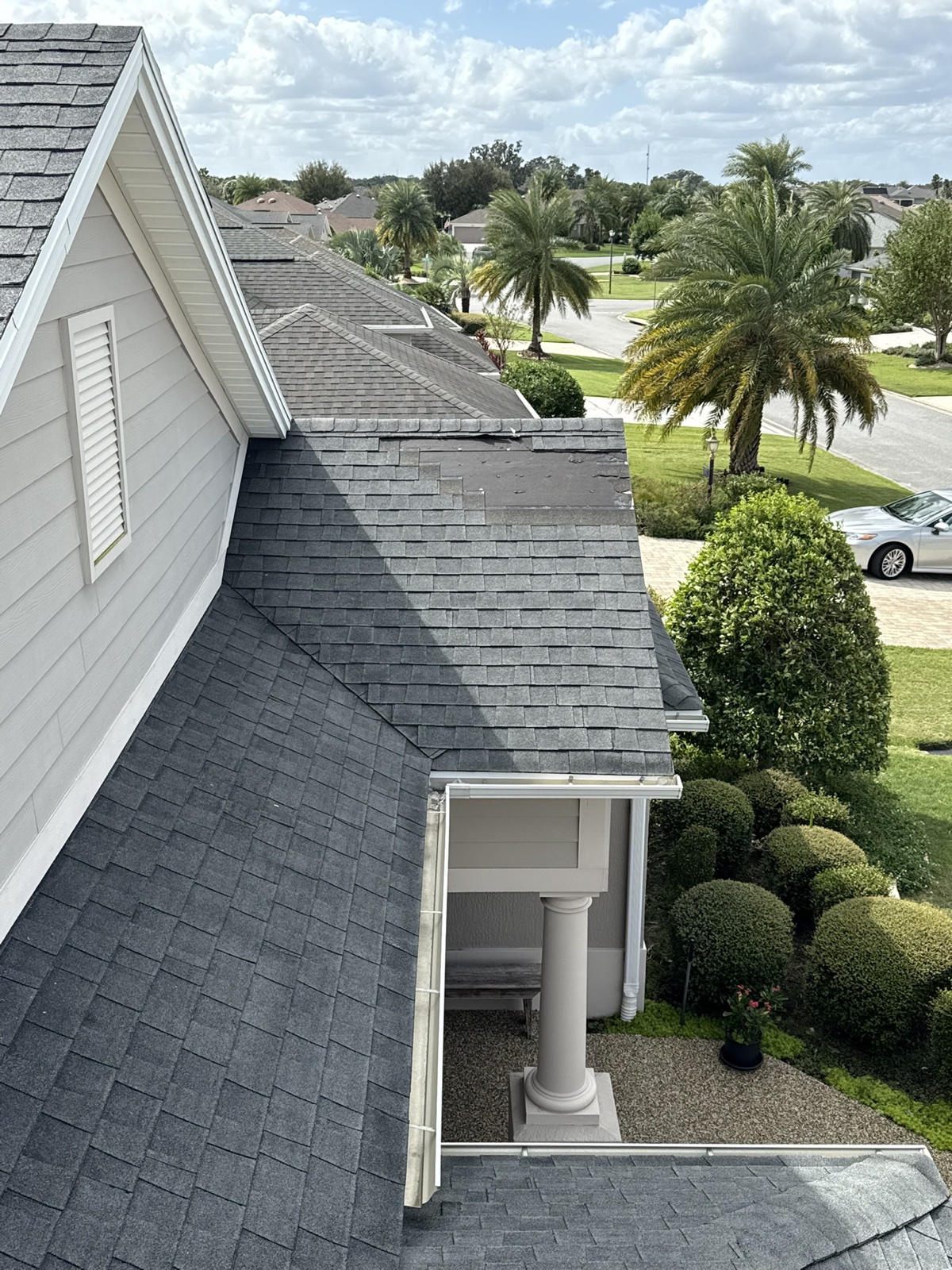 Roof repair area with missing shingles near a roof edge