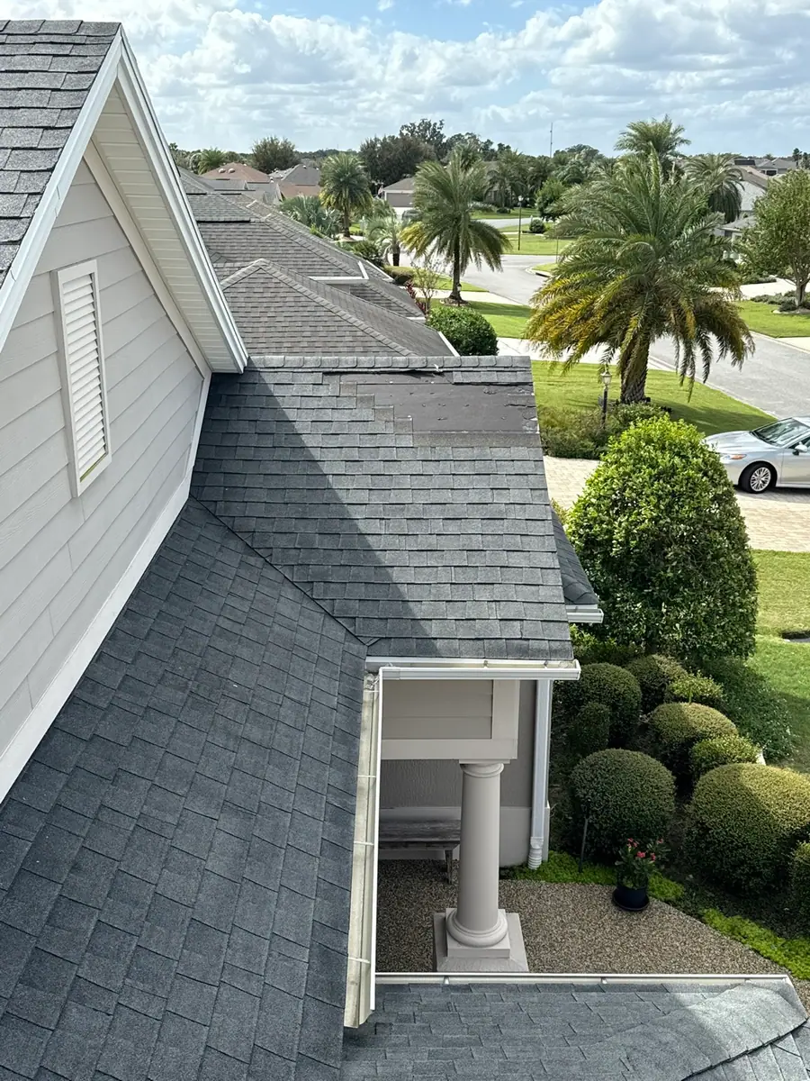 Roof repair area with missing shingles near a roof edge