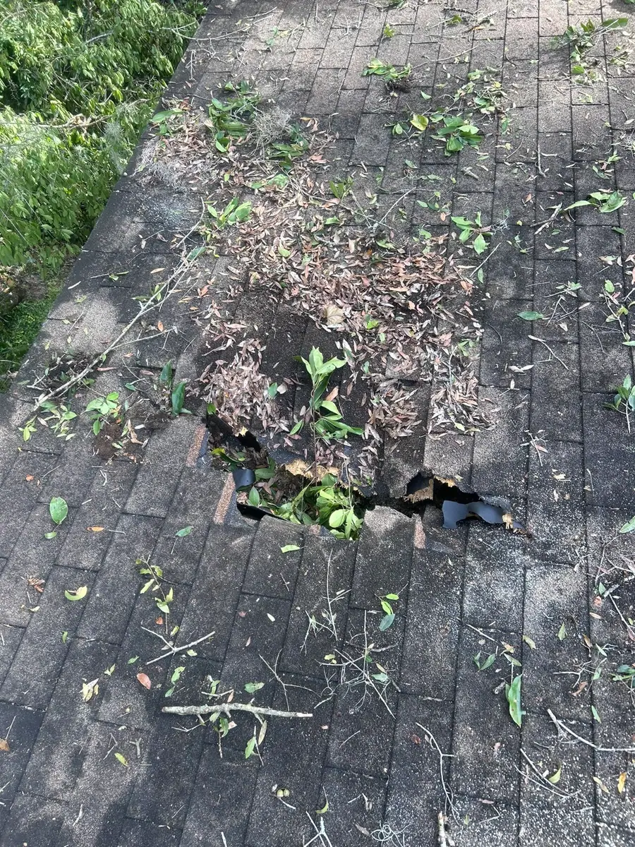 Storm-damaged roof with debris and open decking