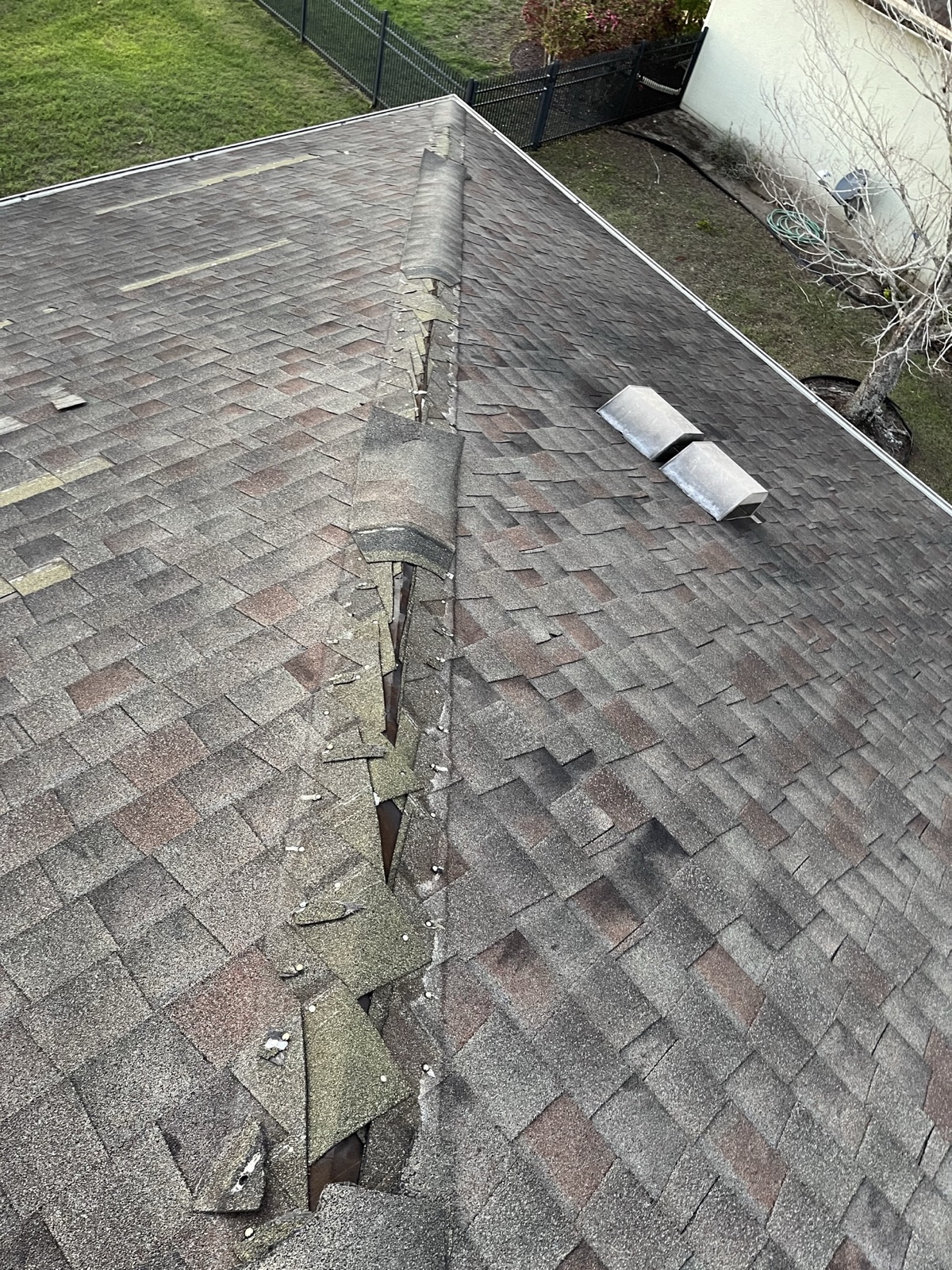 Damaged ridge cap on a shingle roof