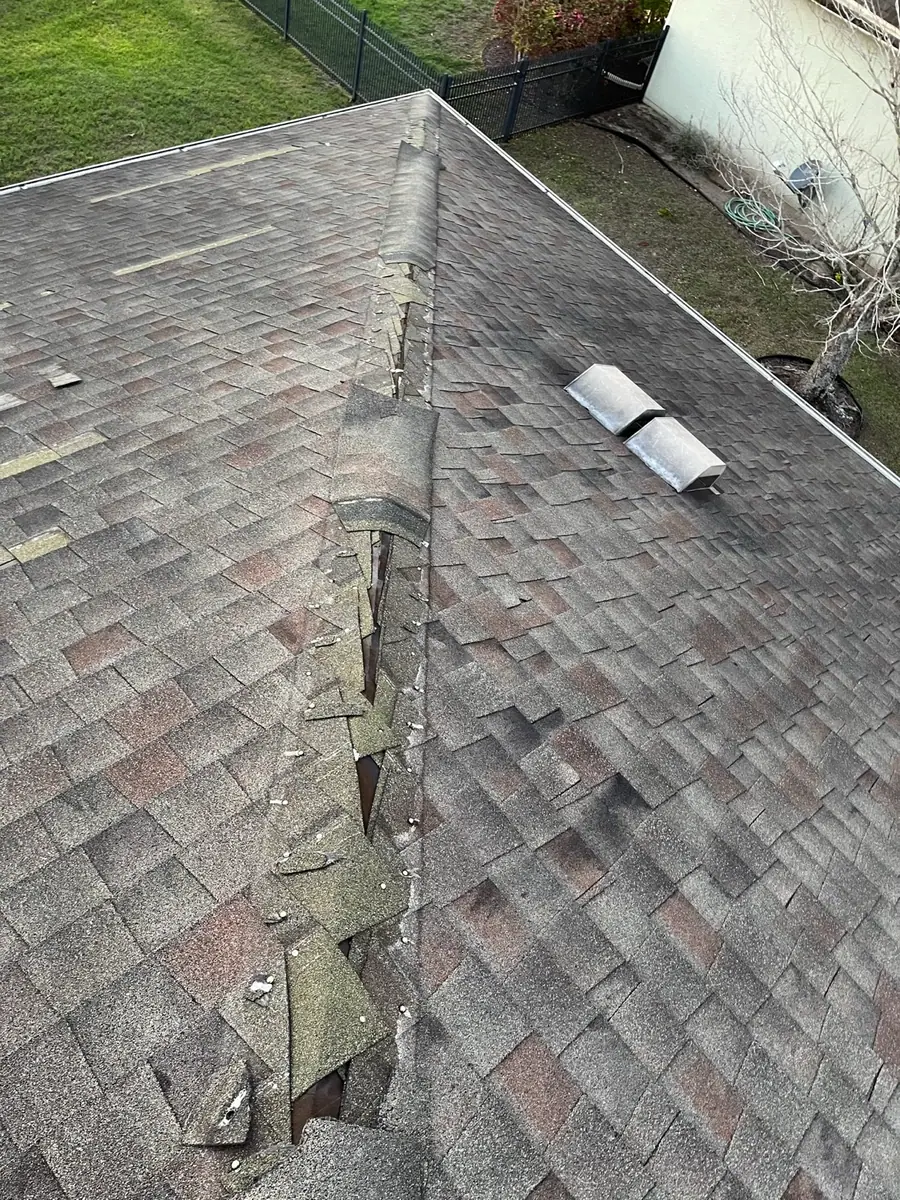 Damaged ridge cap on a shingle roof