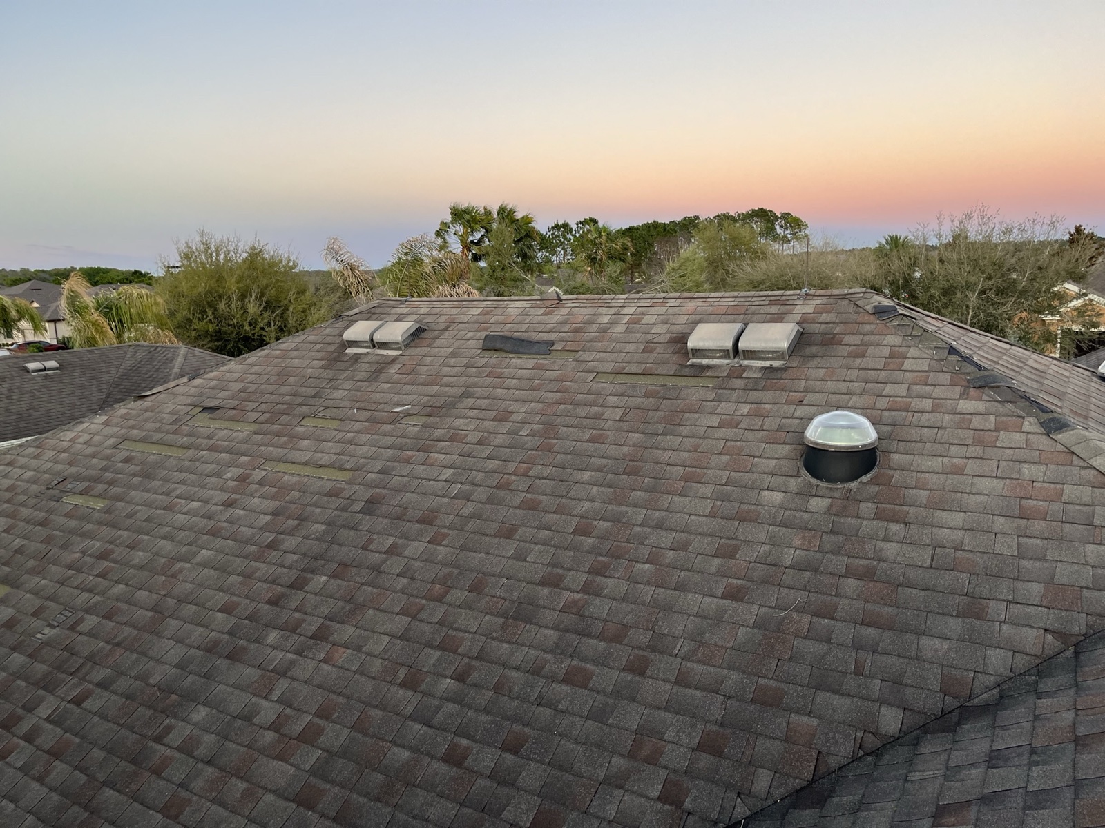 Roof with temporary storm patches at sunset