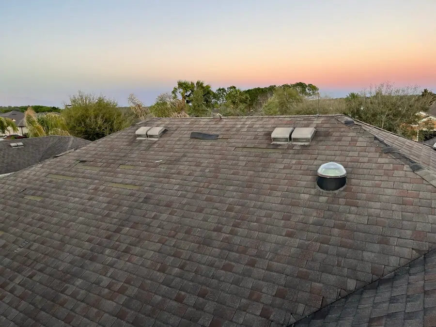 Roof with temporary storm patches at sunset