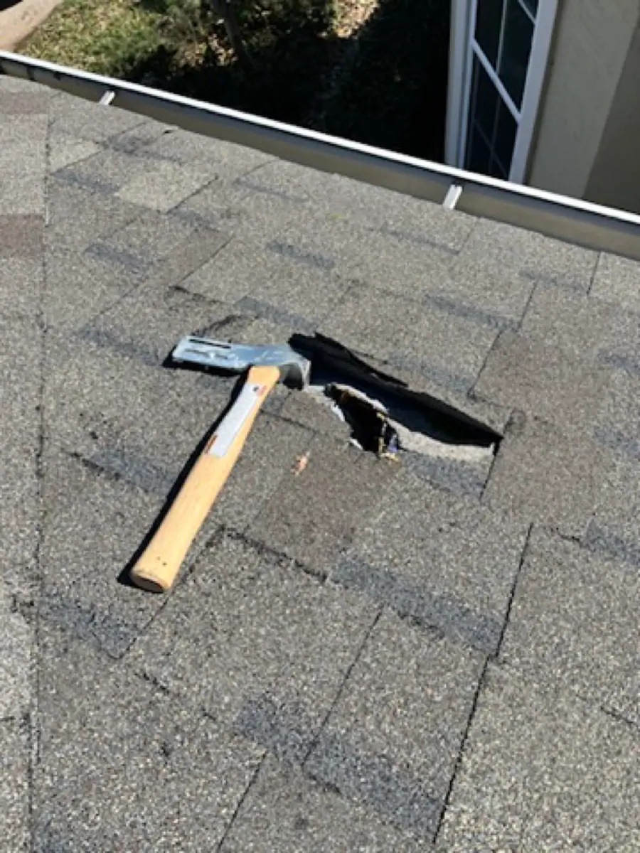 Small roof puncture beside a repair hammer